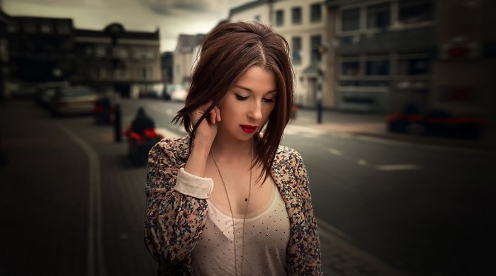Woman with brown hair in a floral jacket on a city street