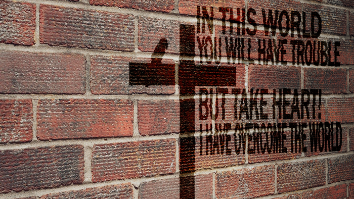 Christian cross and Bible verse on brick wall