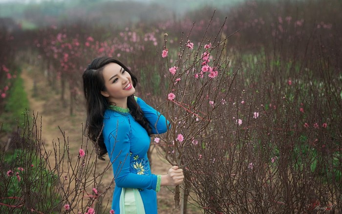 Woman in Traditional Dress Among Blooming Flowers