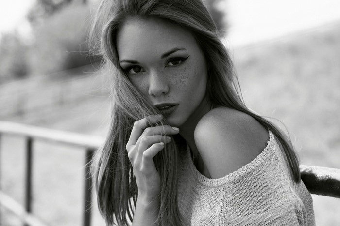 Monochrome portrait of a young woman with freckles