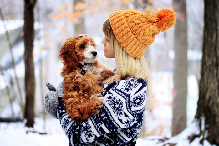 Woman holding a dog in the snow