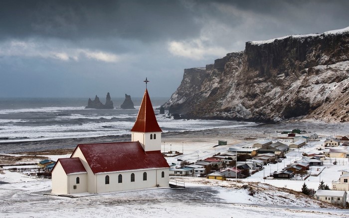 Church and village in Vik, Iceland with sea stacks