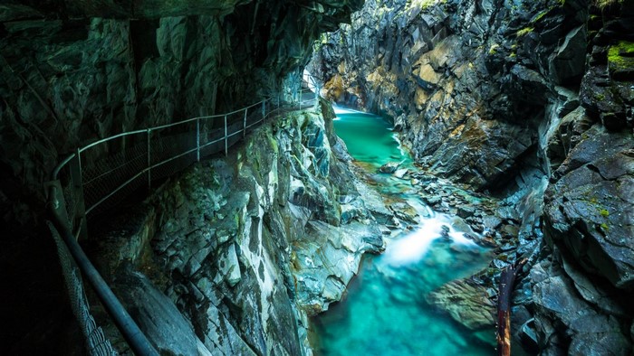 Cave with turquoise river and walking path