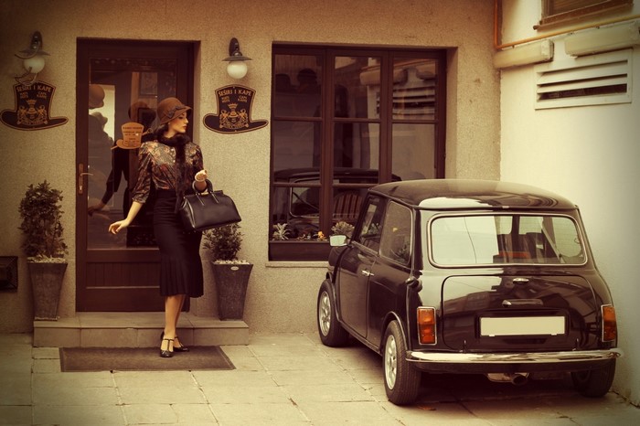 Woman in vintage clothing with a classic Mini Cooper