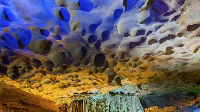 Abstract cave formations with blue and yellow lighting