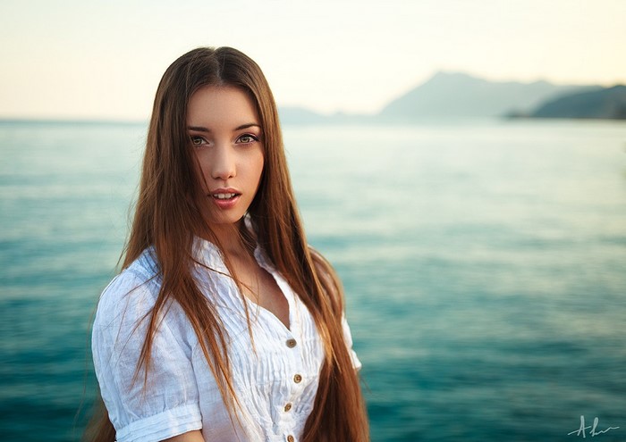 Woman in white shirt by the sea