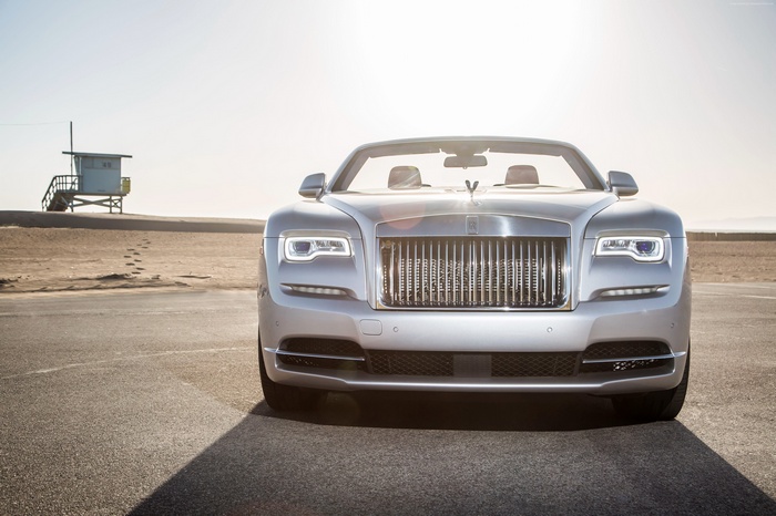 Silver Rolls-Royce Dawn convertible on a beach