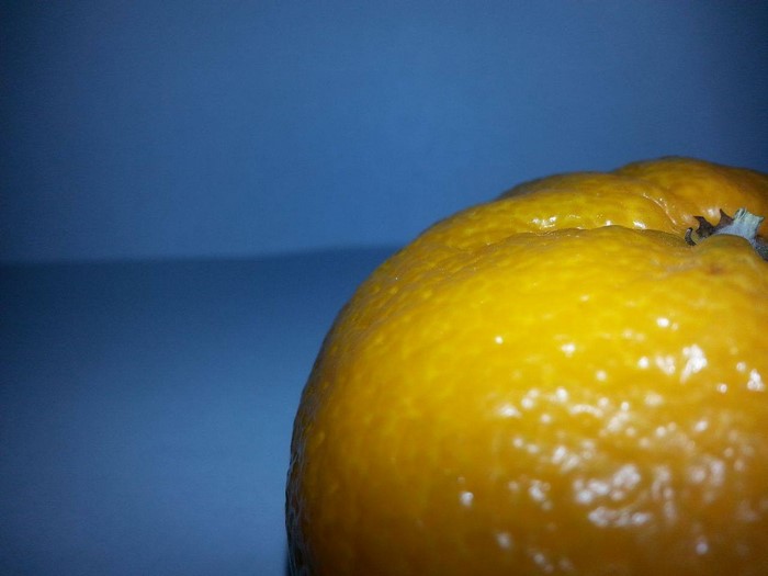Close up of a tangerine on a blue background