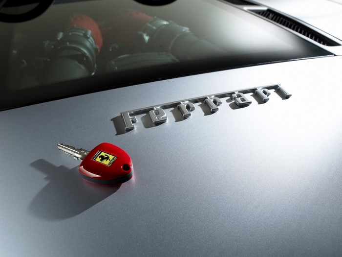 Ferrari car key and emblem on car hood