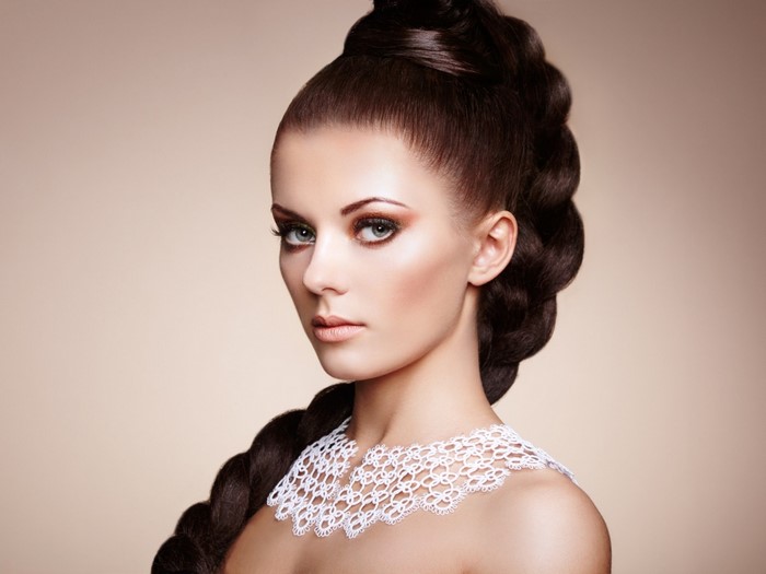 Model with elaborate braided hairstyle and white lace collar