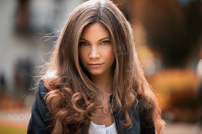 Woman with long brown hair in a black jacket