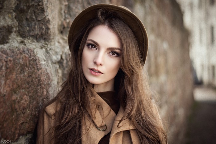Woman with long brown hair wearing a hat and coat