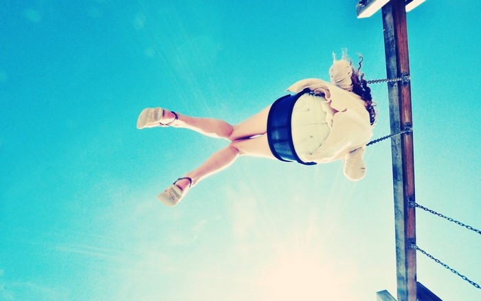 Woman jumping in the air against a blue sky
