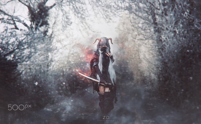 Cosplayer in a horned mask with a sword in winter
