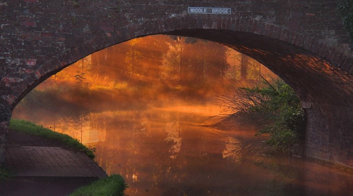 Middle Bridge over canal at sunrise with mist