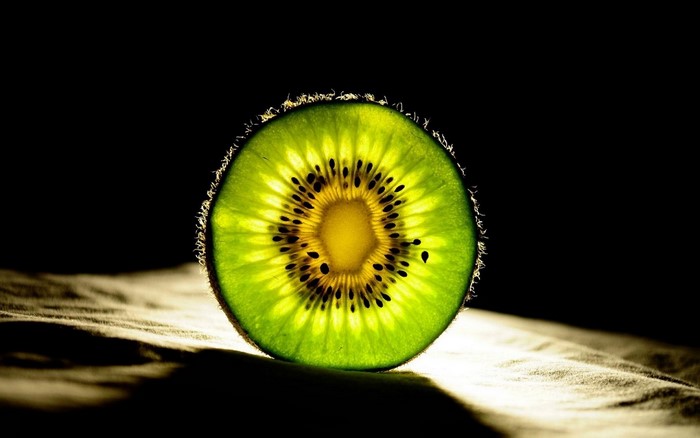 Close-up of a backlit kiwi fruit slice