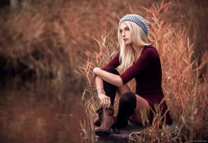 Woman in autumn setting by the water