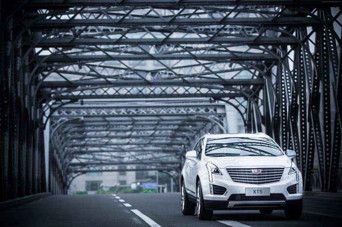 White Cadillac XT5 driving on a bridge