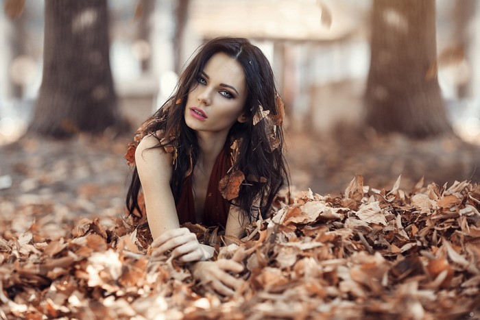 Woman lying in autumn leaves