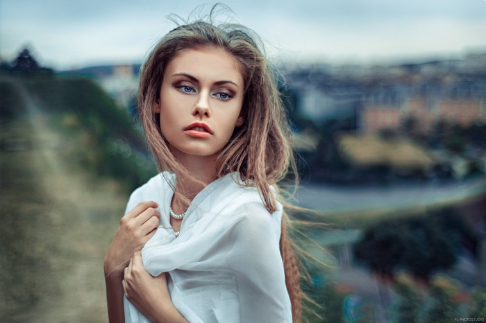 Woman with long hair and pearl necklace outdoors