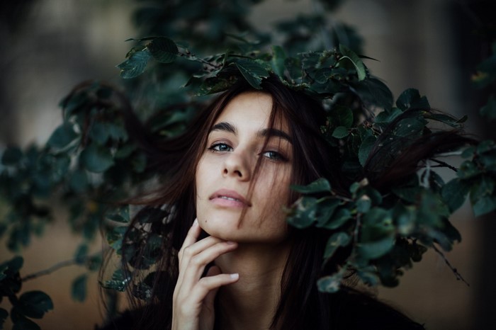 Portrait of a woman surrounded by green leaves