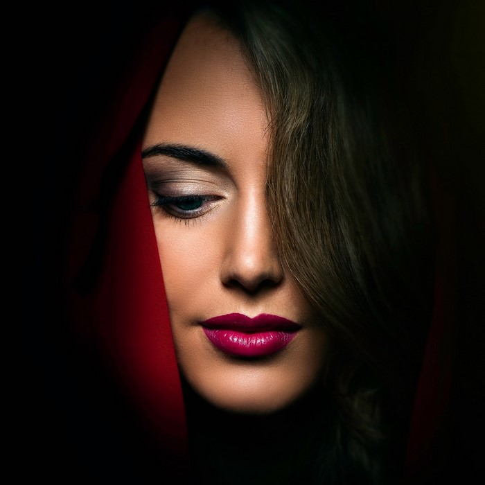 Close up portrait of a woman with red fabric and makeup