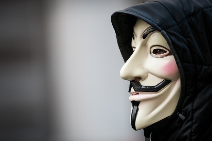 Person wearing an Anonymous mask and hood