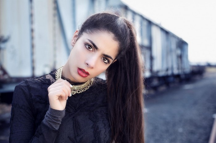 Woman with long dark hair and gold necklace