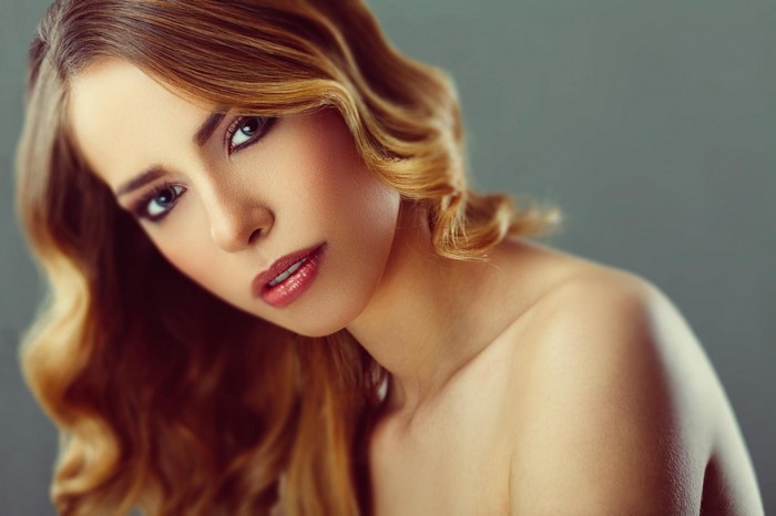 Woman with blonde wavy hair and makeup
