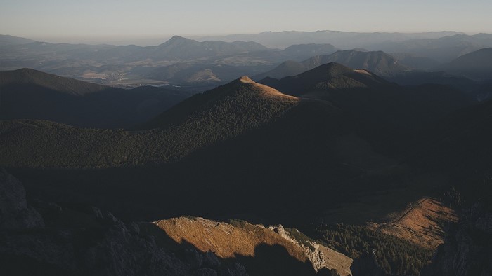 Mountain range at sunrise with sunlit peak