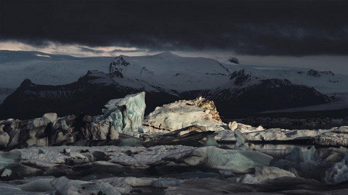 Icebergs floating in glacial lagoon with snow-capped mountains