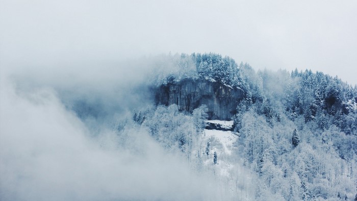 Snow-covered mountain peak shrouded in mist
