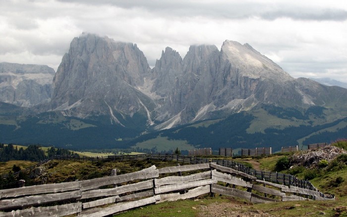 Wooden fence in front of the Dolomites mountain range