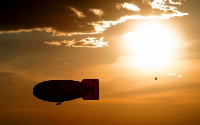 Blimp and hot air balloon at sunset