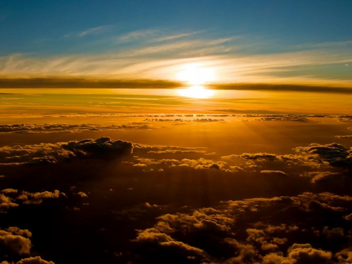 Sunset over clouds with sun rays