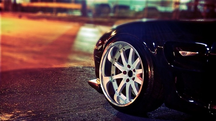 Close-up of a black sports car wheel and fender