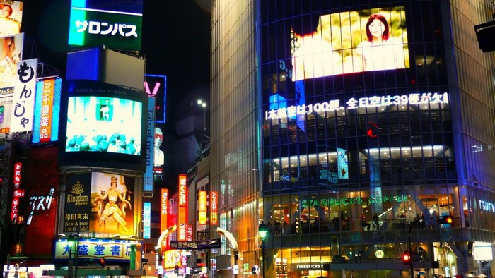 Shibuya Crossing at Night with Neon Signs and Starbucks