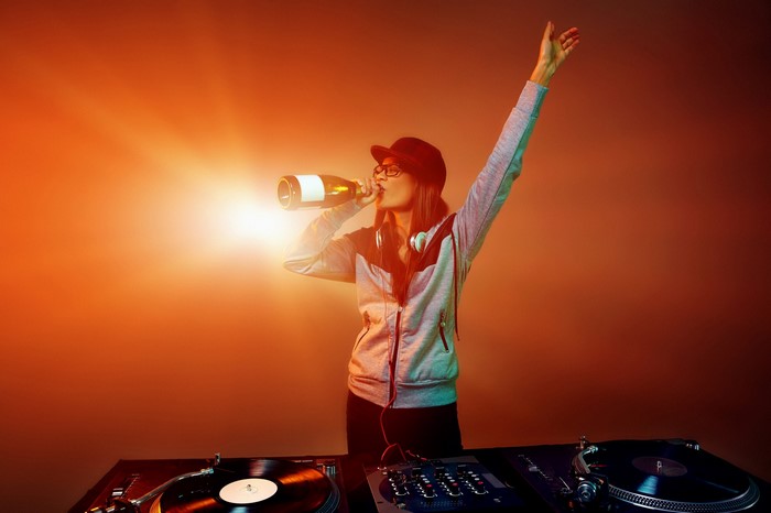 DJ drinking champagne at turntables