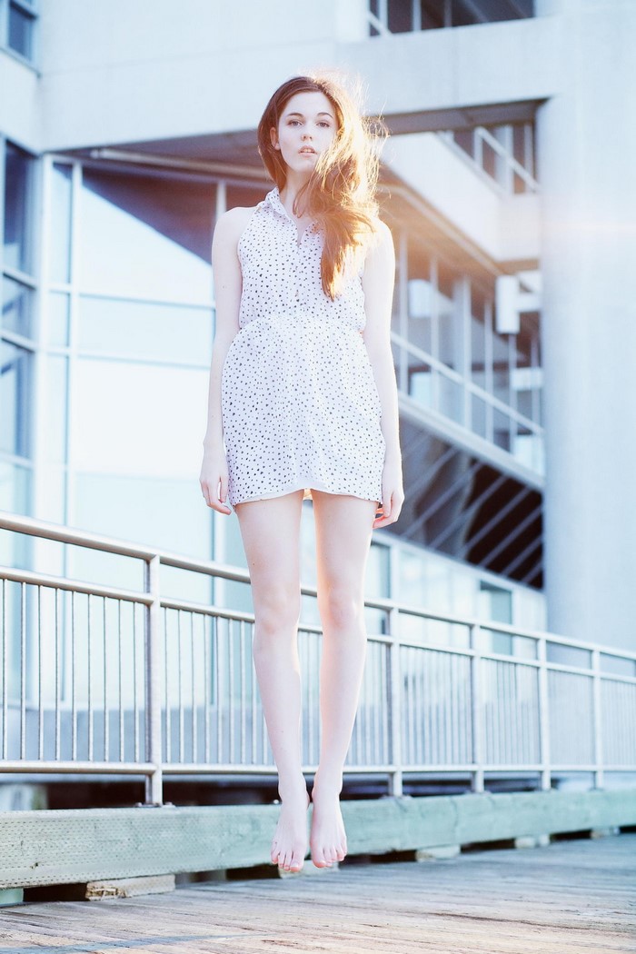 Woman in polka dot dress levitating outdoors