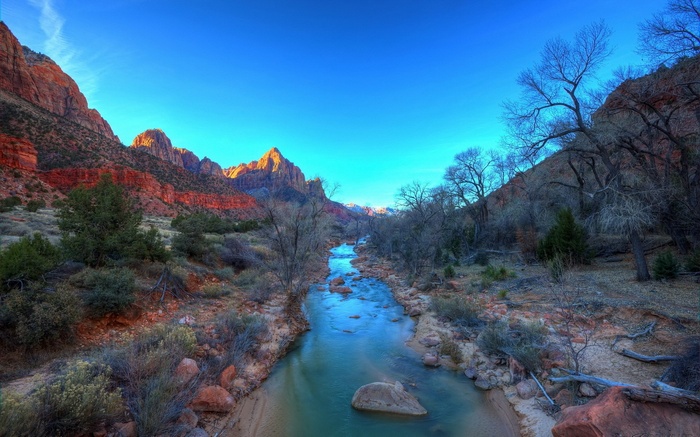 River flowing through a canyon with red rock mountains