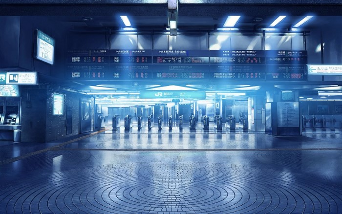 Train station entrance with digital displays and turnstiles