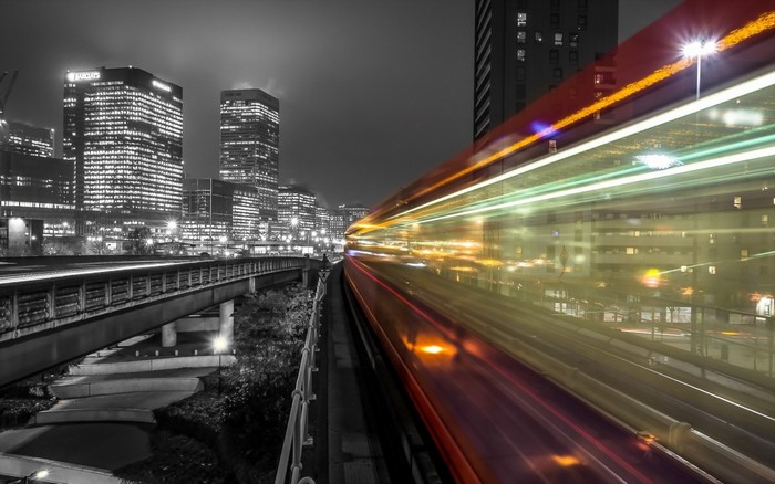 Cityscape at night with light trails from a train