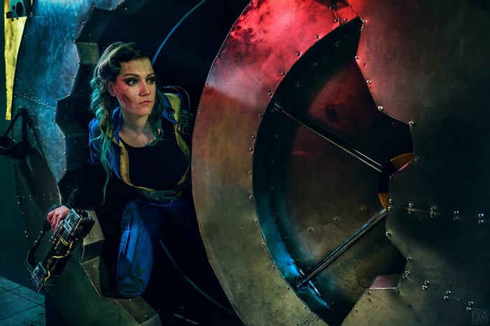 Cosplayer dressed as Fallout Vault Dweller with a weapon