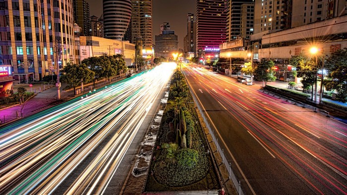 City street at night with light trails from traffic