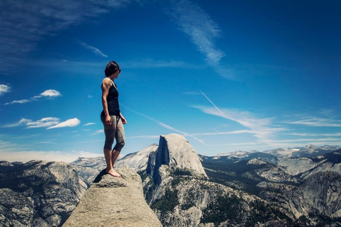 Woman standing on a rock overlooking Yosemite Valley