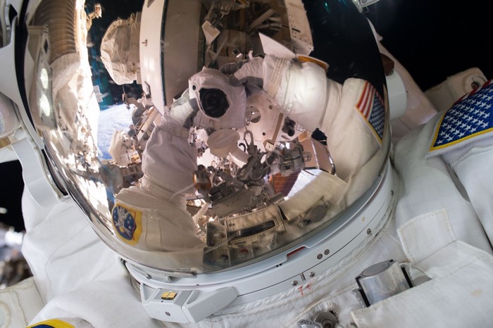 Astronaut in space with Earth reflection