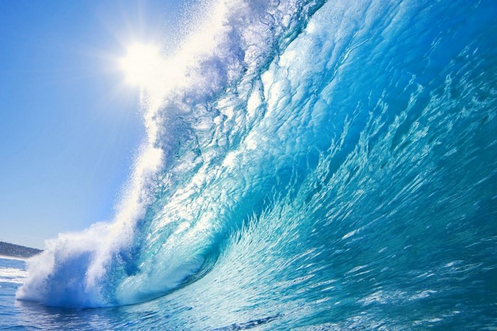 Sun shining on a powerful ocean wave