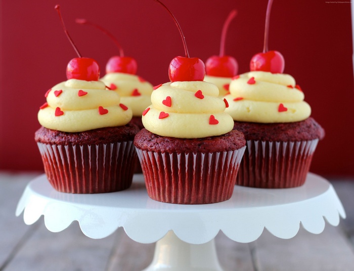 Red velvet cupcakes with cherries and heart sprinkles