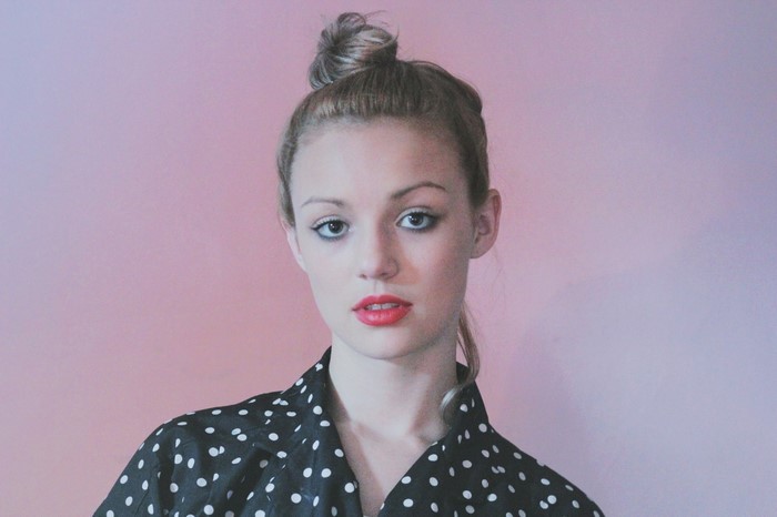 Woman with polka dot shirt and top bun