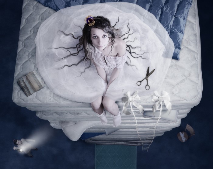 Woman in white dress with crown on mattress